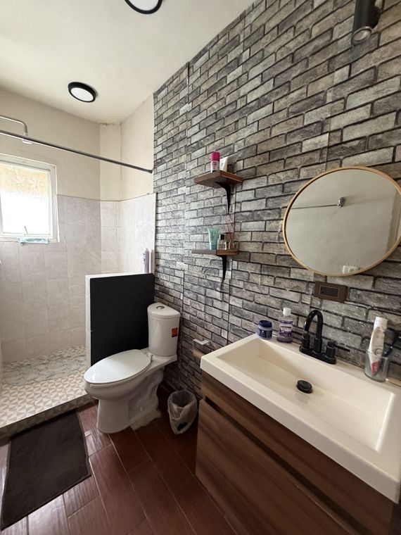 Baño completo con muro de ladrillo